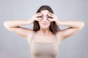 Eine Frau praktiziert Gesichtsyoga zur Hautstraffung um Falten zu verhindern