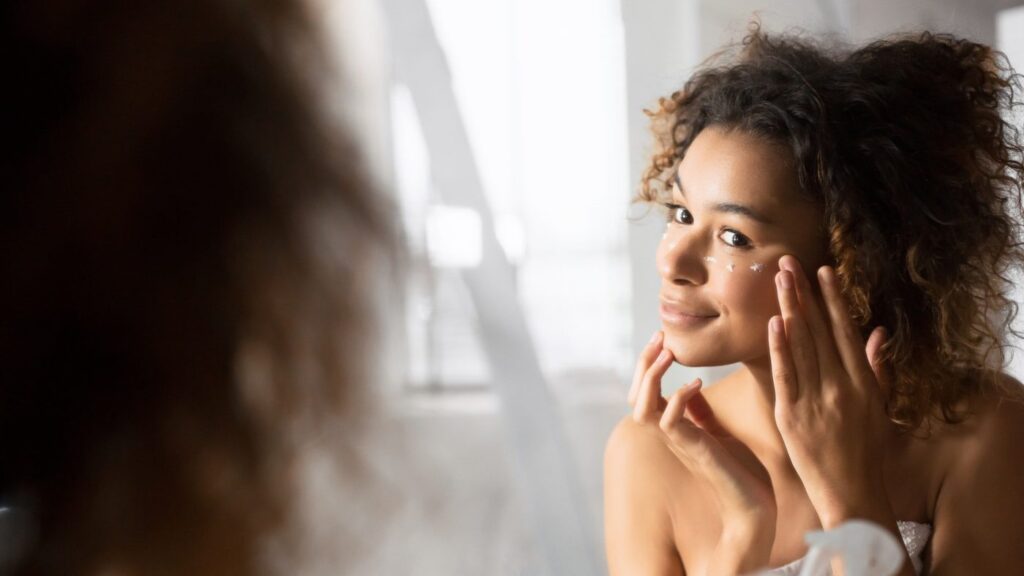 Hautpflege-Routine. Frau beim Auftragen von Augencreme um Falten zu verhindern und Augenringe zu mildern